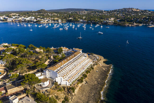 Spain, Balearic Islands, Costa de la Calma, Aerial view of coastal town in summer with sailboats sailing in background — Stock Photo
