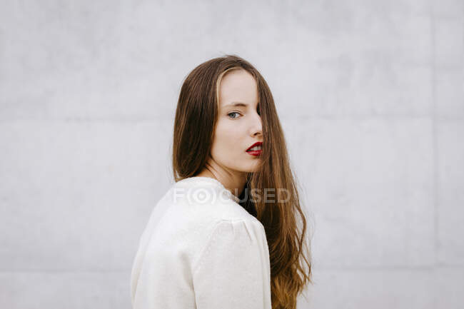 Porträt einer jungen Frau mit langen Haaren und roten Lippen — Stockfoto