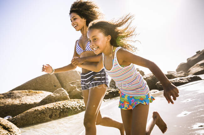 Щаслива мати і дочка біжать на пляжі — стокове фото
