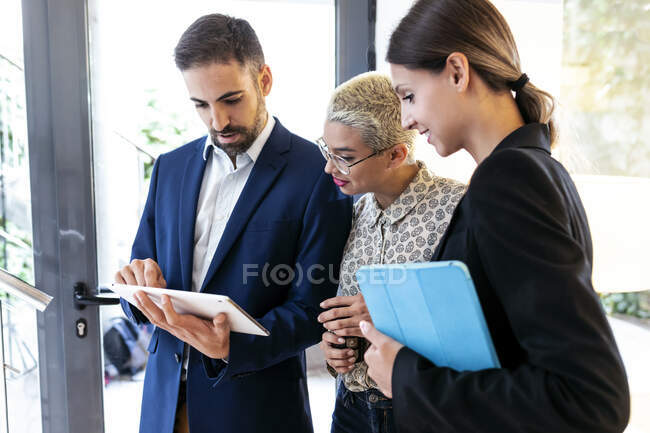 Empresario mostrando tableta a colegas en la oficina - foto de stock