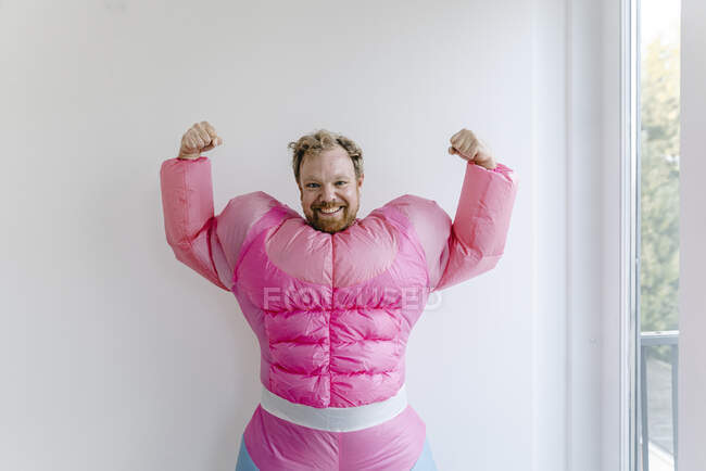Stolzer Mann im rosafarbenen Bodybuilder-Kostüm lässt seine Muskeln spielen — Stockfoto