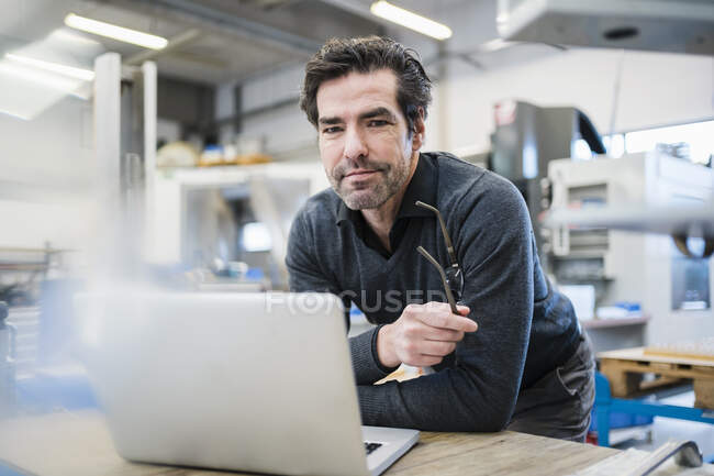 Портрет бизнесмена с помощью ноутбука на заводе — стоковое фото