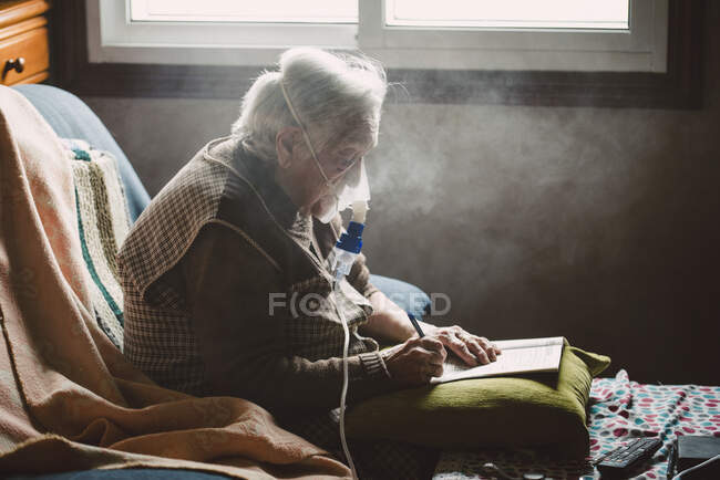 Donna anziana che usa l'inalatore a casa — Foto stock