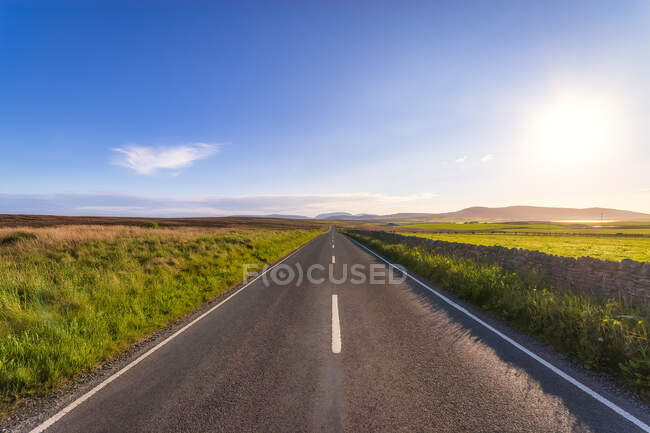 Шотландия, Оркнейские острова, Южный Рональдсей, Пустая дорога, пересекающая сельский ландшафт — стоковое фото