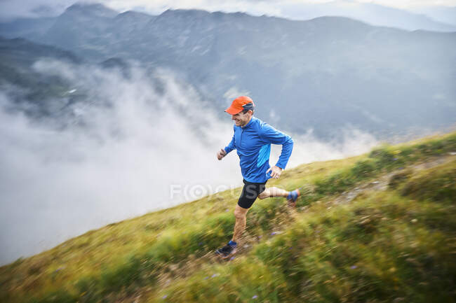 Hombre corriendo en las montañas - foto de stock