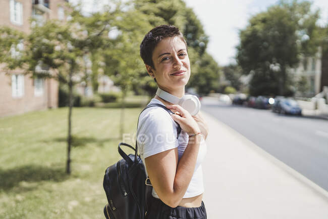 Portrait de femme souriante avec casque et sac à dos — Photo de stock