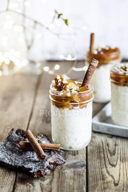 Jars of rice pudding with cinnamon and roasted plums — Stock Photo
