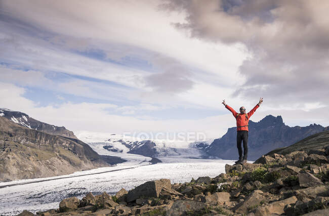 Зрілий чоловік стоїть у Національному парку Скафтафелл і дивиться на льодовик Ватнайокутль (Ісландія). — стокове фото