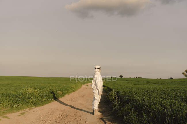 Man wearing protective suit and mask in the countryside — Stock Photo