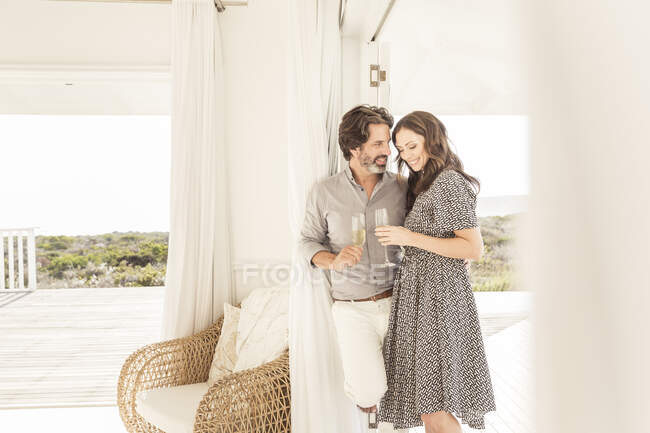 Счастливая пара пьет шампанское в доме отдыха — стоковое фото