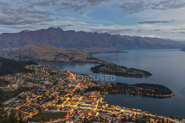 Nouvelle-Zélande, Otago, Queenstown, Ville sur la rive du lac Wakatipu au crépuscule avec des montagnes en arrière-plan — Photo de stock