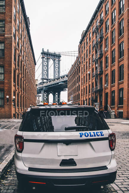 USA, New York, New York City, Police car on street with Manhattan Bridge in background — Stock Photo