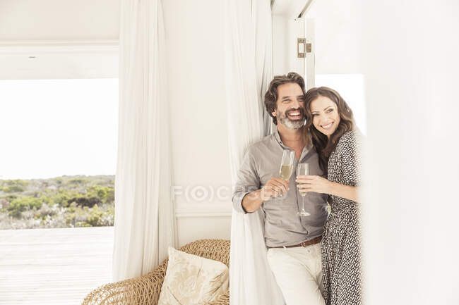 Счастливая пара пьет шампанское в доме отдыха — стоковое фото