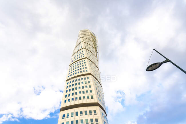 Low angle view of Turning torso against cloudy sky — Stock Photo