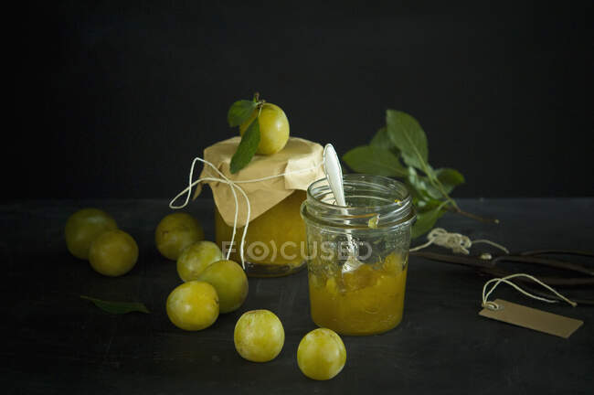 Studio shot of greengages and jars of homemade plum jam — Stock Photo