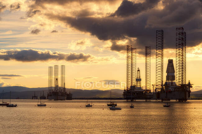Schottland, Cromarty Firth, Ölplattformen im Meer bei Sonnenuntergang — Stockfoto