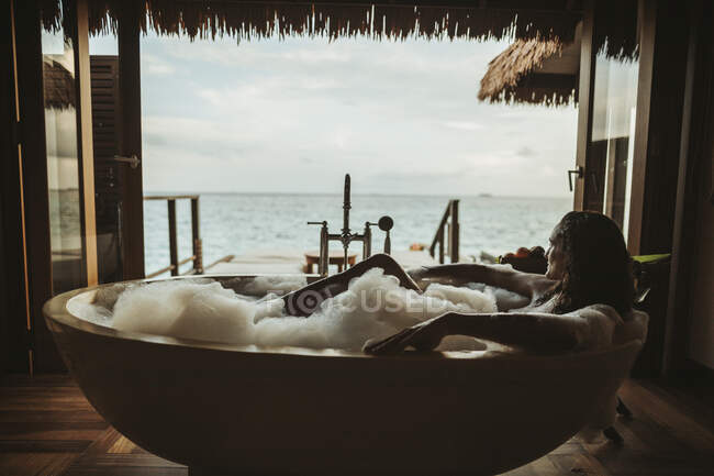 Женщина отдыхает в ванне с видом на море, остров Магудхуваа, атолл Гаафу Дхаалу, Мальдивы — стоковое фото