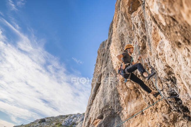 Mujer escalando en roca cara - foto de stock