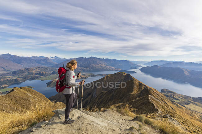 Mujer de pie en el mirador del Pico Roys, mirando al Monte Aspiring, Lago Wanaka, Isla Sur, Nueva Zelanda - foto de stock