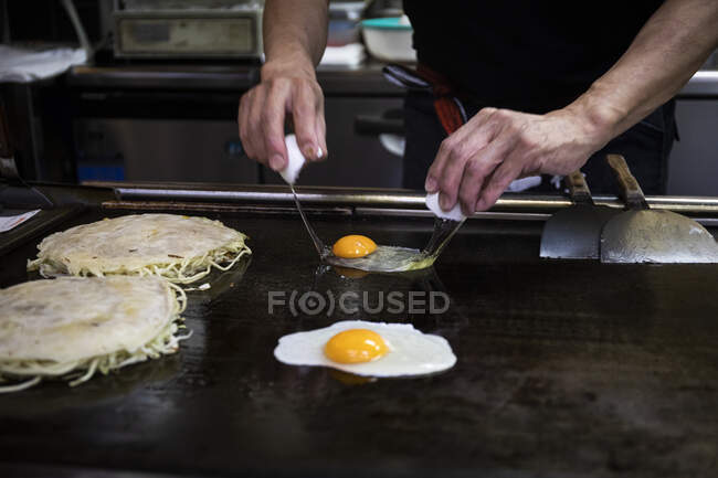 Japón, Kioto, Primer plano del chef preparando Okonomiyaki en el restaurante - foto de stock