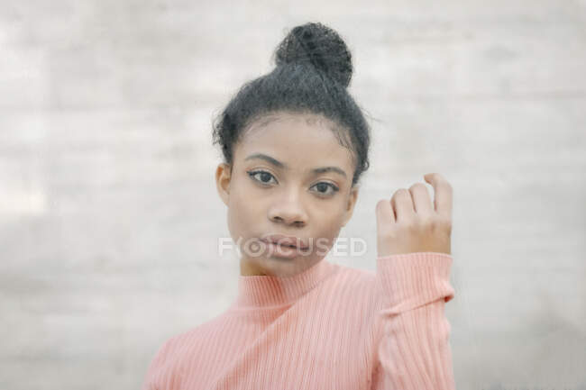 Porträt einer schönen jungen Frau hinter Glasscheibe — Stockfoto