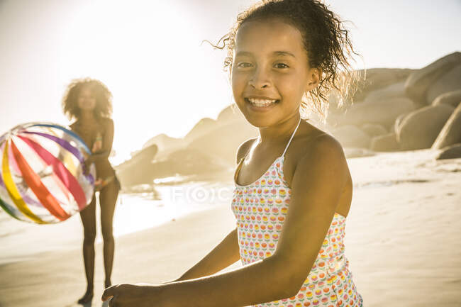 Portrait of happy girl playing with her mother on the beach — Stock Photo