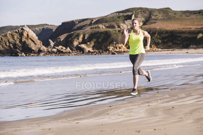 Жіночий бігун на пляжі. — стокове фото
