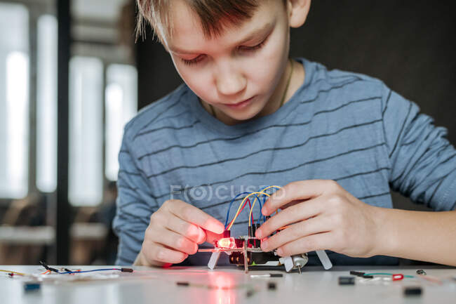 Junge baut Roboter zu Hause zusammen — Stockfoto