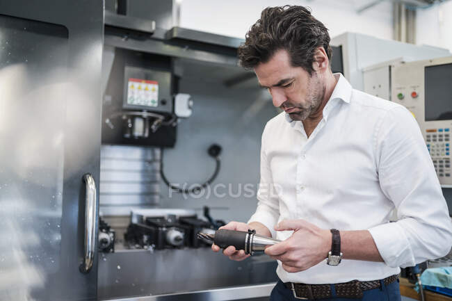 Man holding drillhead in a factory — Stock Photo