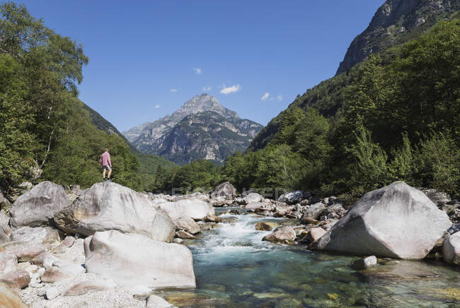 Uomo in piedi sulla roccia sul fiume Verzasca, Valle Verzasca, Ticino, Svizzera — Foto stock