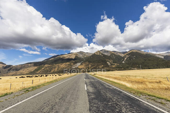 Nouvelle-Zélande, district de Grey, Inchbonnie, Nuages sur la State Highway 73 vide avec des montagnes en arrière-plan — Photo de stock