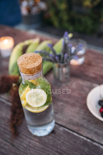Agua de desintoxicación con limón y menta sobre la mesa - foto de stock