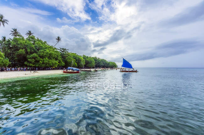 Papua Nueva Guinea, Islas Trobriand, Isla Kitava, playa con turistas y barcos - foto de stock