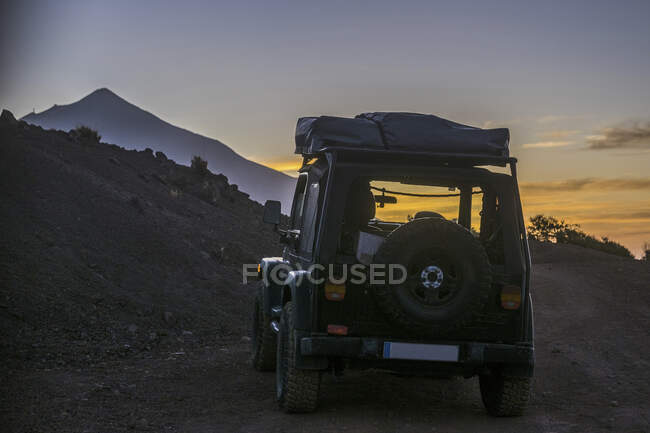 Espanha, Tenerife, Vista traseira do carro off-road no Parque Nacional de Teide ao pôr do sol — Fotografia de Stock