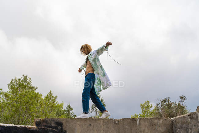 Молодой блондин балансирует на стене — стоковое фото