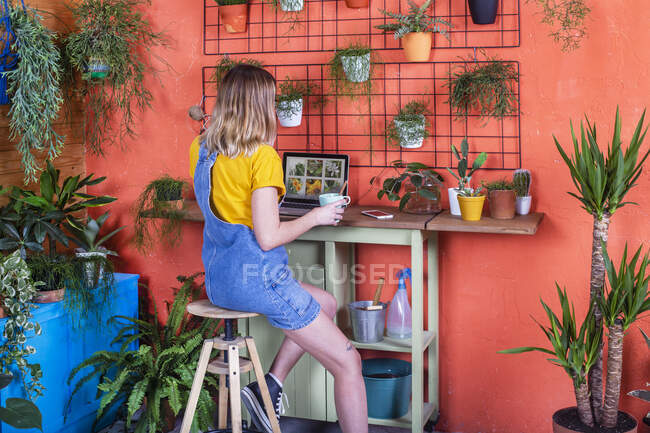 Frau benutzt Laptop auf ihrer Terrasse — Stockfoto