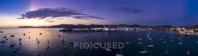 Spain, Mallorca, Santa Ponsa, Aerial panorama of boats floating in coastal water at purple dusk with town in background — Stock Photo