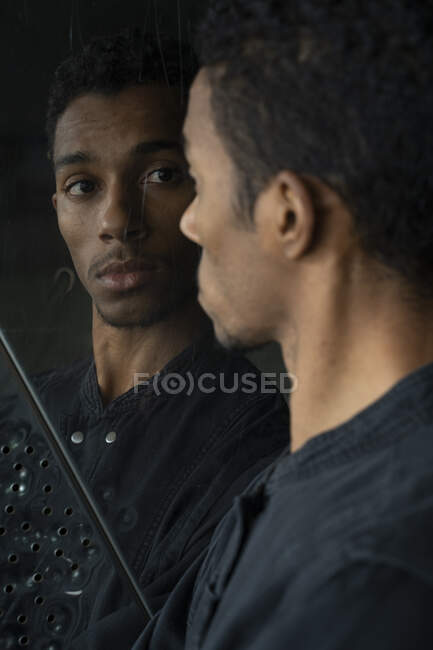 Ritratto di giovane uomo che guarda l'immagine dello specchio — Foto stock