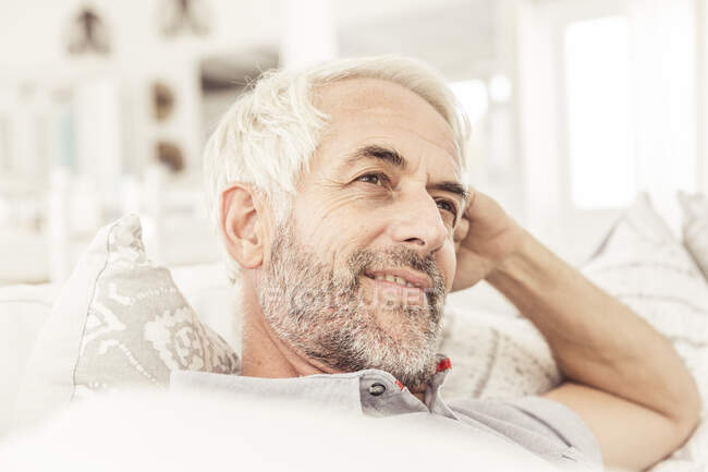 Portrait of mature man on couch in living room — Stock Photo