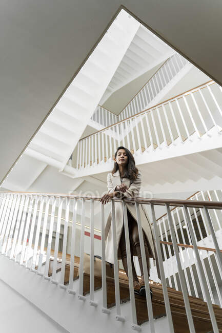 Jovem mulher de pé na escada — Fotografia de Stock