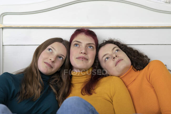 Ritratto di tre sorelle testa a testa guardando la distanza — Foto stock