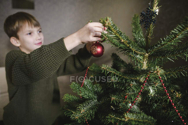 Junge schmückt Weihnachtsbaum — Stockfoto