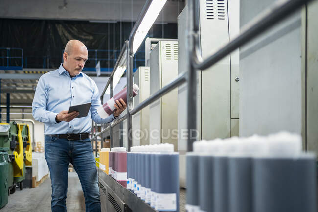 Empresario usando tableta en una fábrica - foto de stock