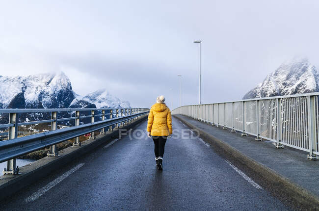 Turista cruzando un puente en Hamnoy, Lofoten, Noruega - foto de stock