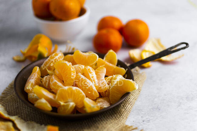 Heap of freshly peeled mandarines on frying pan — Stock Photo