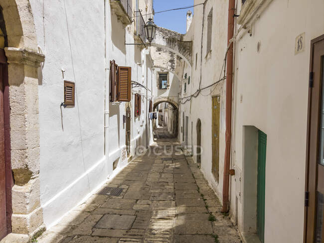 Italy, Province of Brindisi, Ostuni, Empty alley between old white-colored city houses — Stock Photo