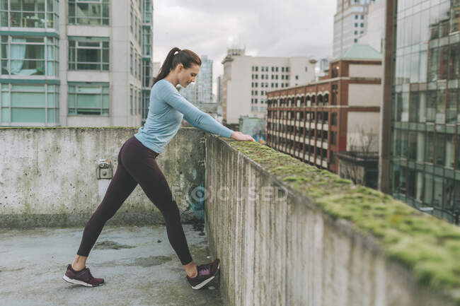 Femme s'étirant avant l'exercice dans la ville, Vancouver, Canada — Photo de stock