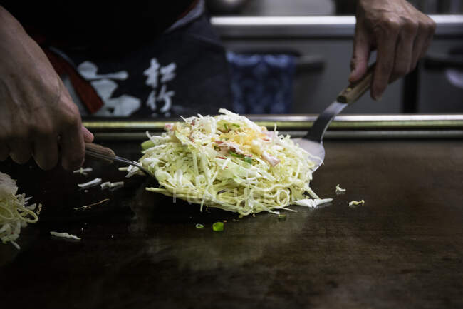 Япония, Киото, крупный план повара, готовящего Окономияки в ресторане — стоковое фото