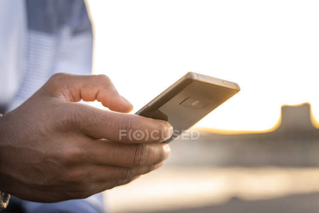 Primer plano del hombre utilizando el teléfono inteligente al aire libre - foto de stock