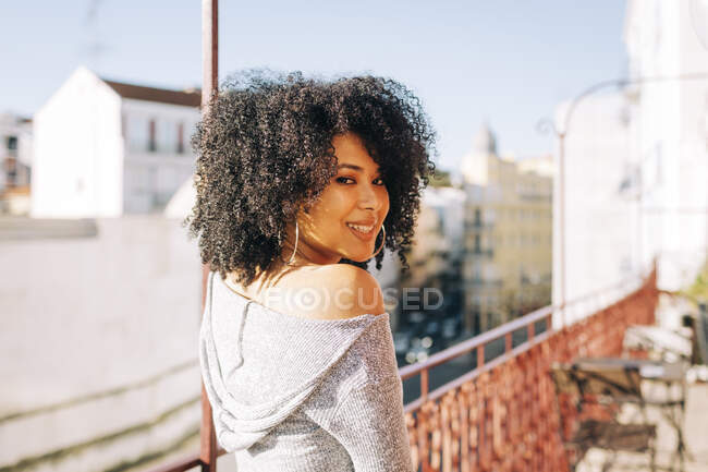 Портрет молодой женщины с вьющимися волосами на балконе — стоковое фото